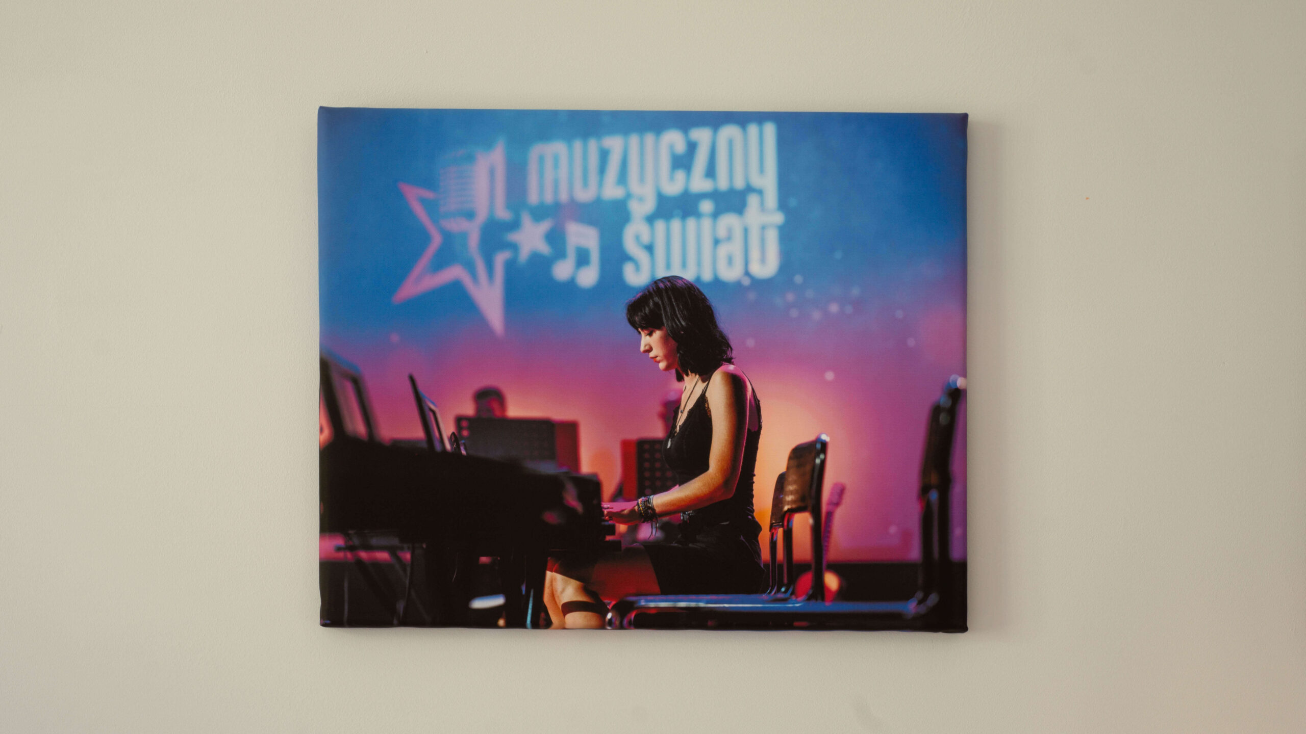 Fotoobraz przedstawiający kobietę grającą na pianinie podczas koncertu z napisem Muzyczny Świat w tle