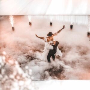 Para młoda tańcząca na sali wśród dymu i efektów świetlnych podczas wesela